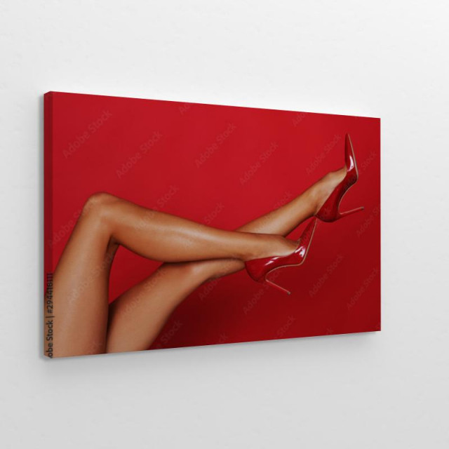 Długie kobiece nogi na czerwonym tle obraz